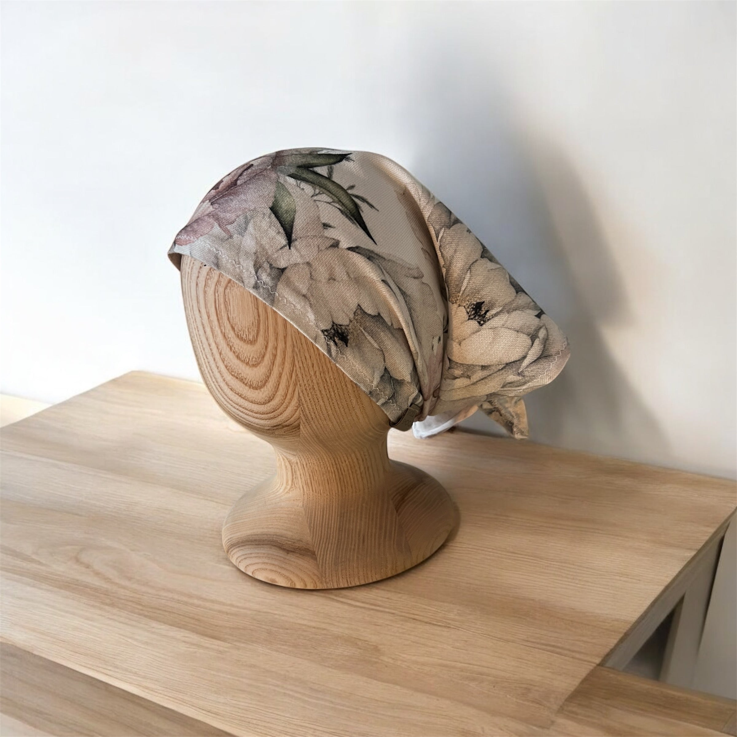 Floral headscarf on a wooden mannequin bust on a wooden surface