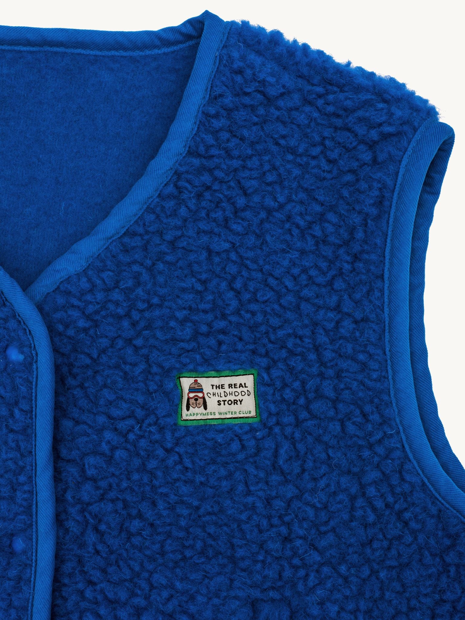 Blue merino wool vest with a brand label on a white background