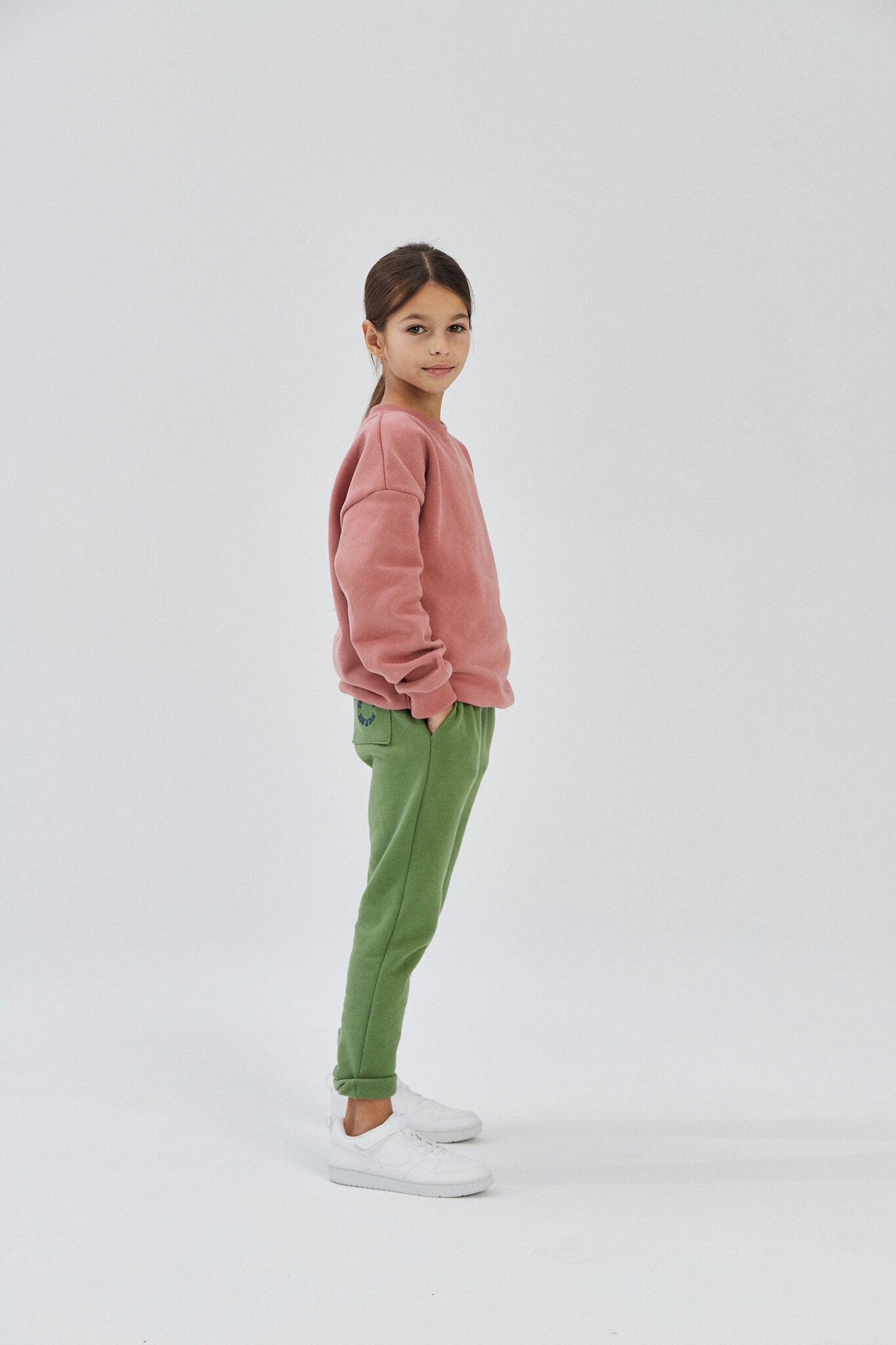 Child wearing green organic cotton sweatpants and a pink top