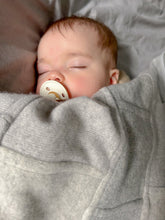 Sleeping baby wrapped in grey cashmere blanket