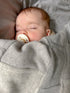 Sleeping baby wrapped in grey cashmere blanket