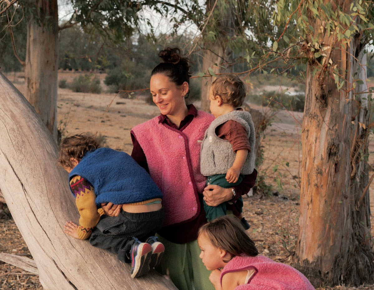 Woman with three children outdoors near trees