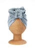 a light blue baby and toddler turban on a wooden mannequin with a white plain background