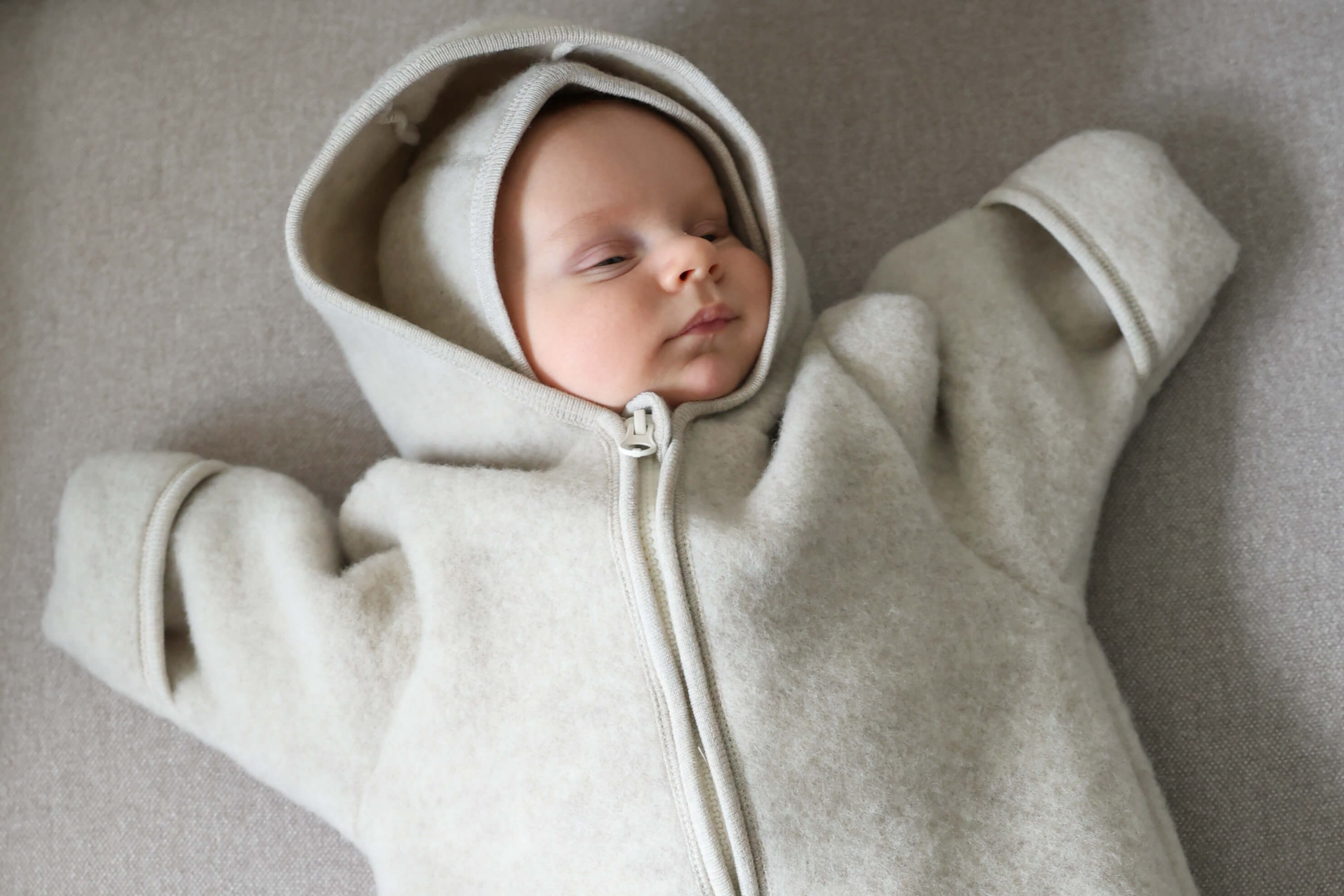 Baby wearing a light gray hooded onesie