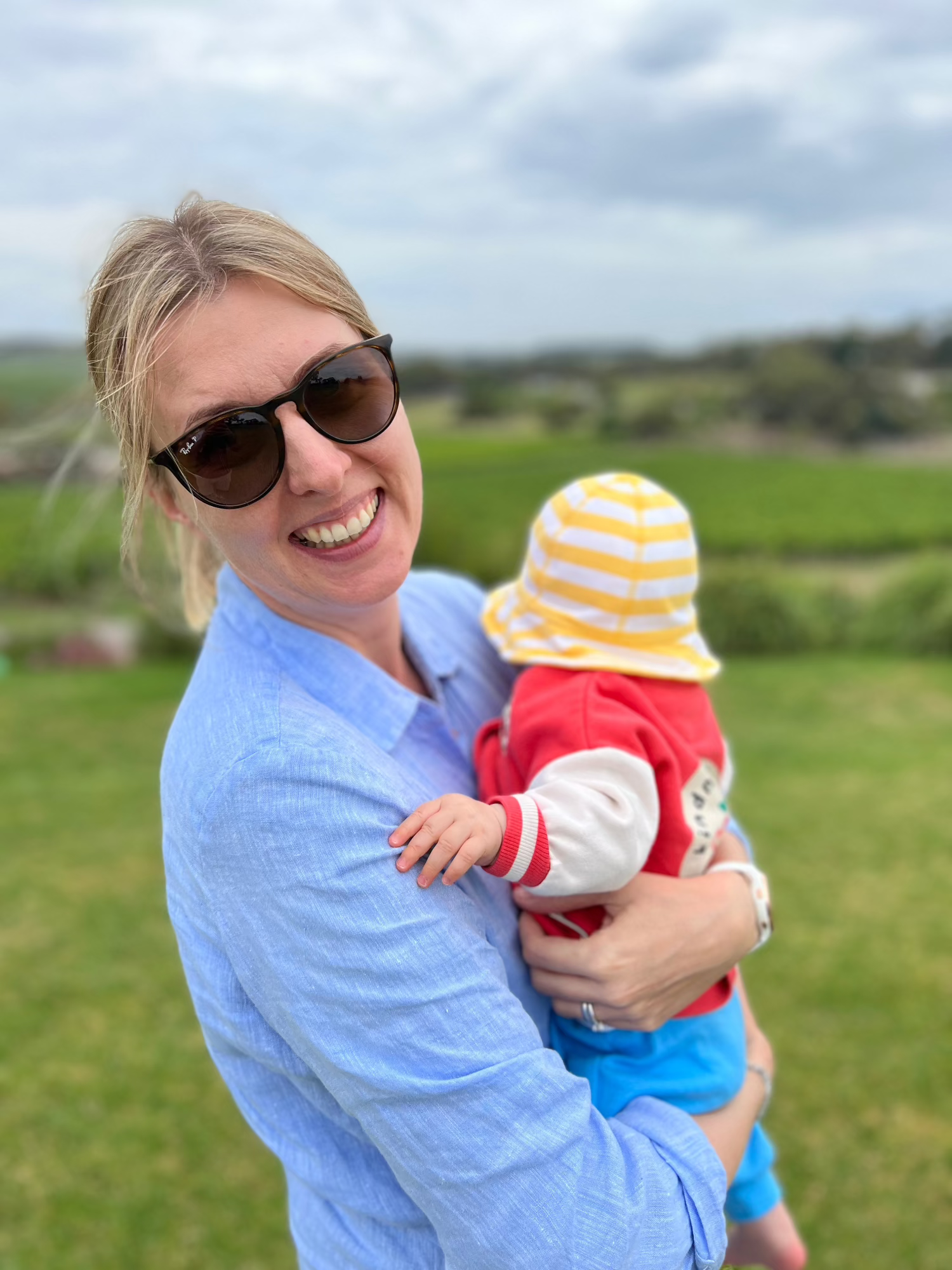 Woman holding a child outdoors with a scenic background