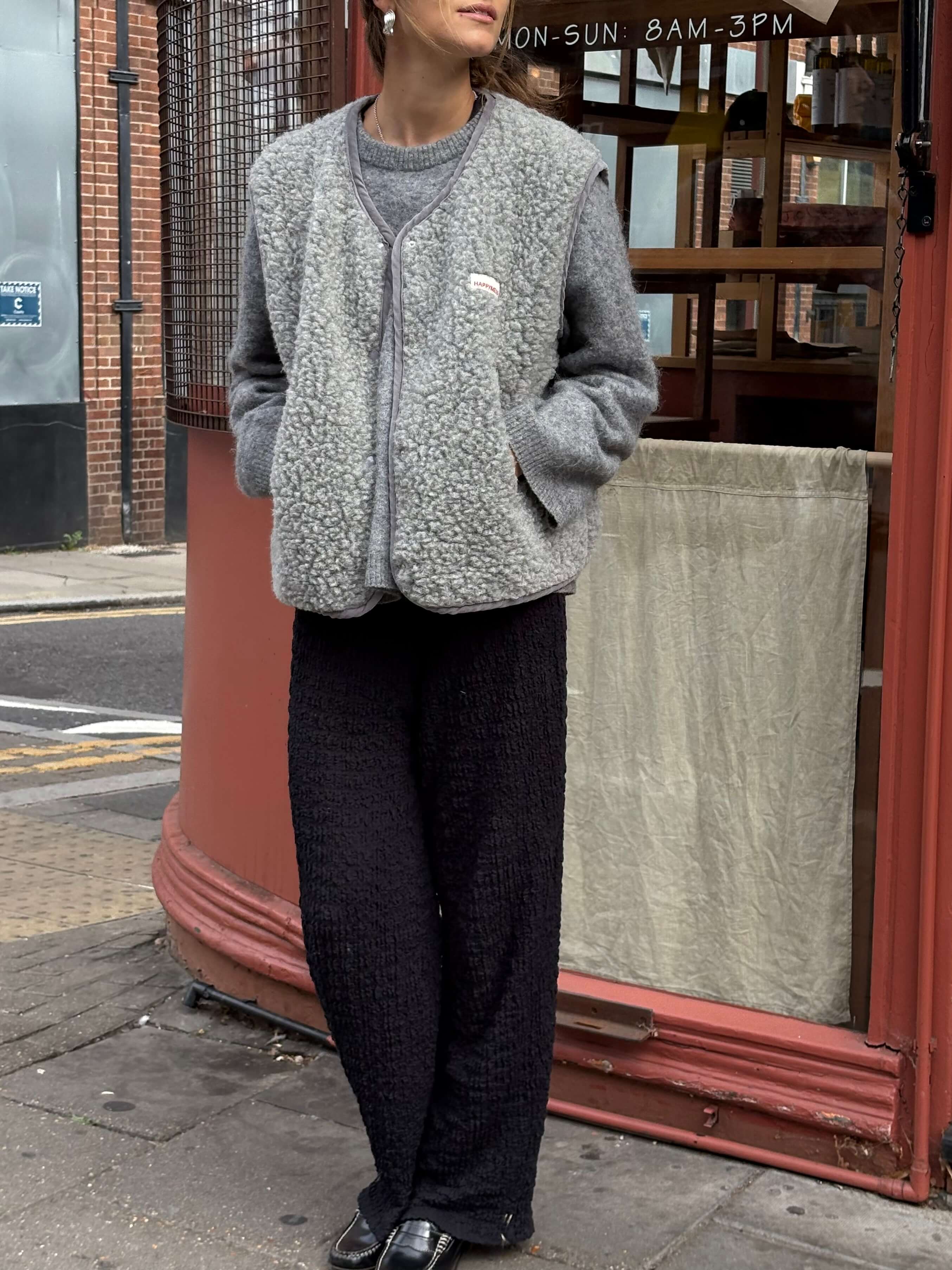 Woman wearing a gray fleece vest and dark pants