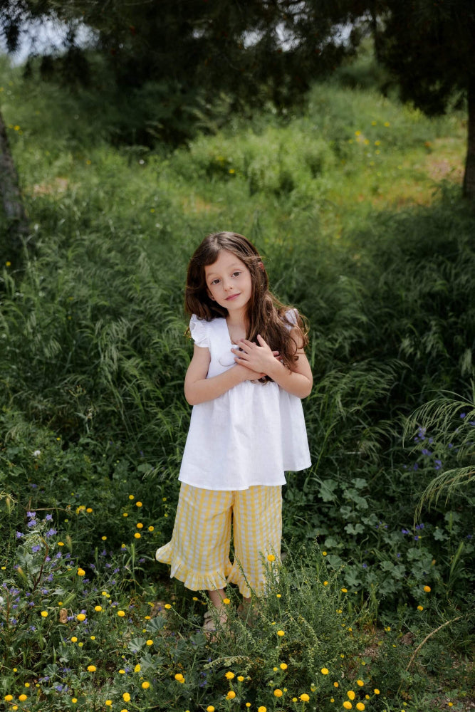 Young girl in a white top and yellow pants