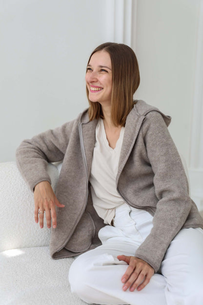 Woman wearing a gray cardigan over a white top and pants