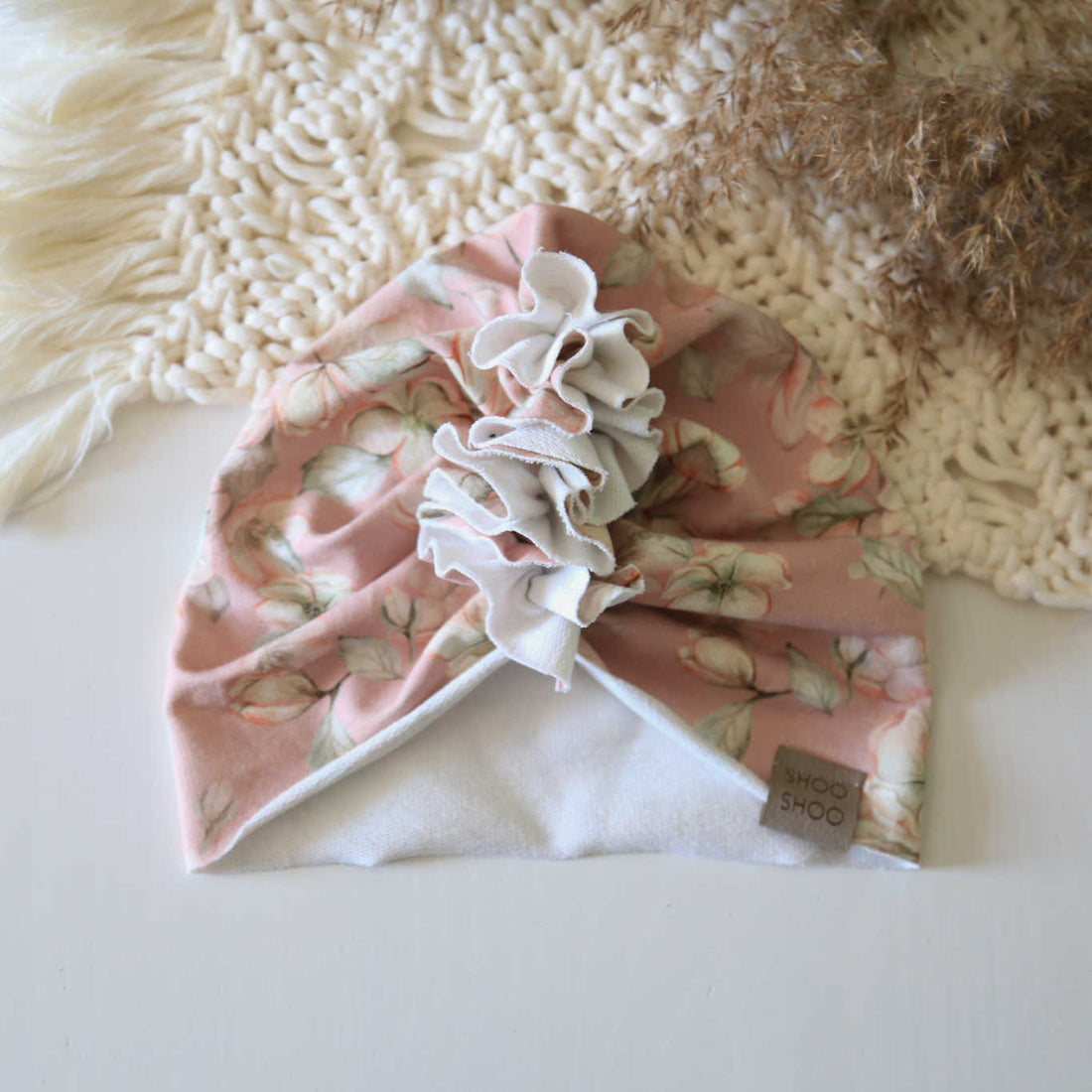 baby turban in light pink color with floral print on it