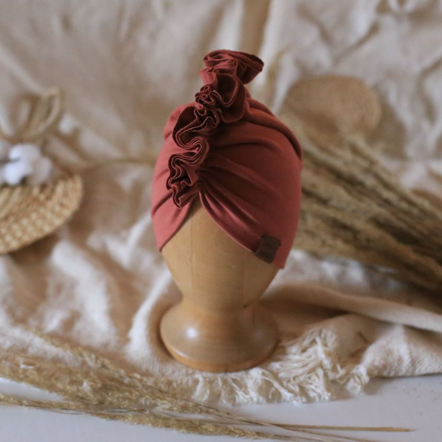 baby turban in color marsala on a wooden head mannequin 