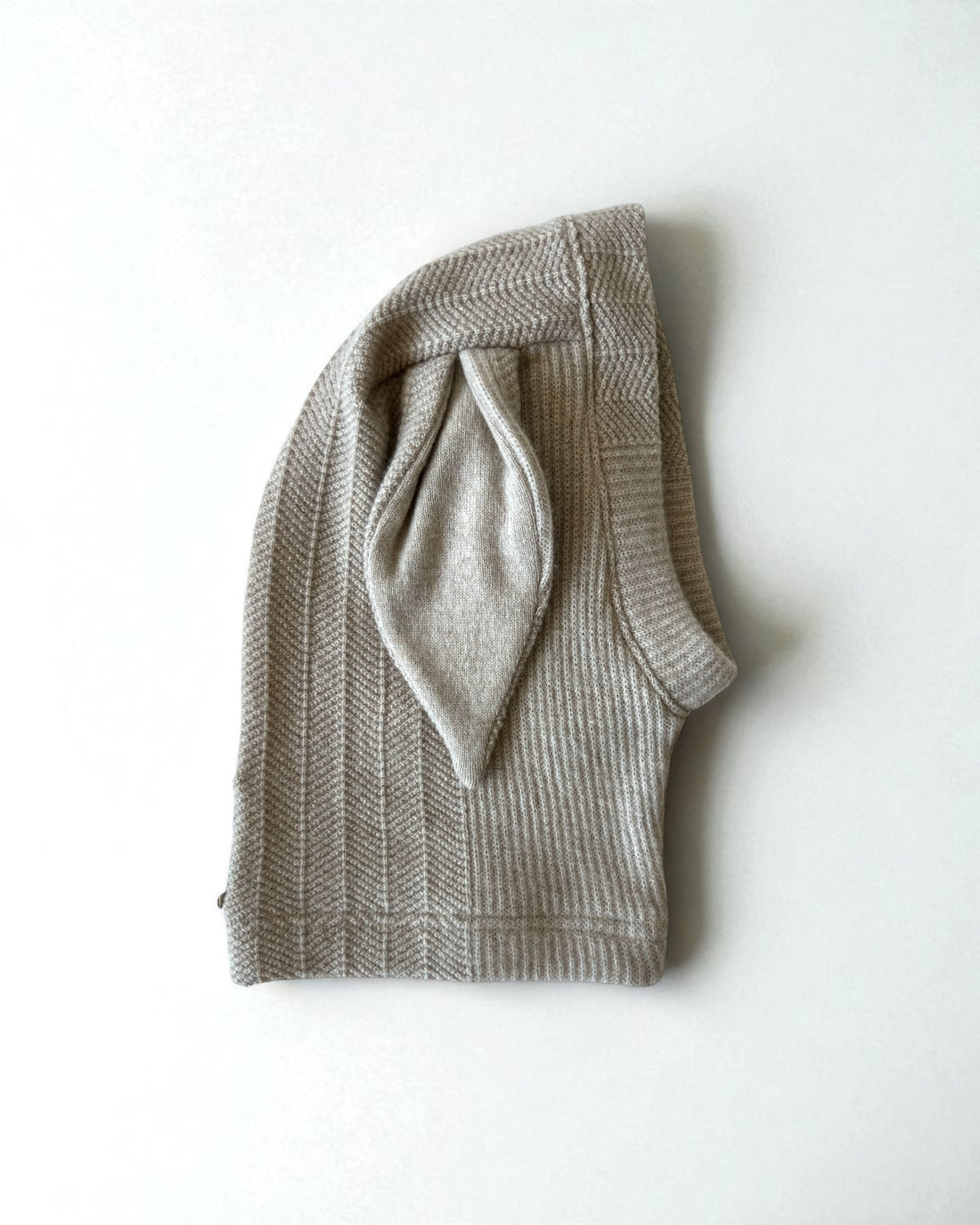 Knitted beige balaclava with bunny ears on a white background