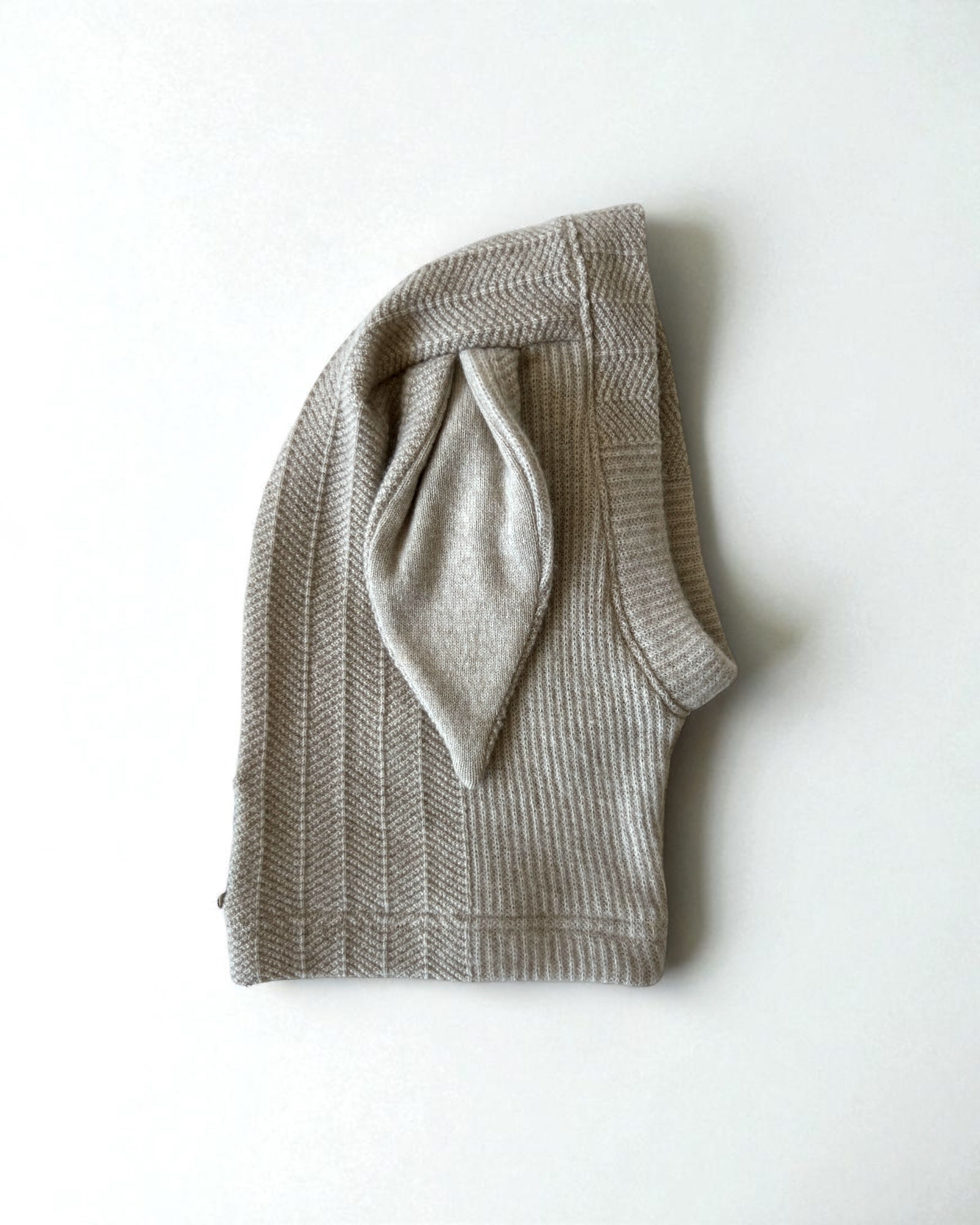 Knitted beige balaclava with bunny ears on a white background