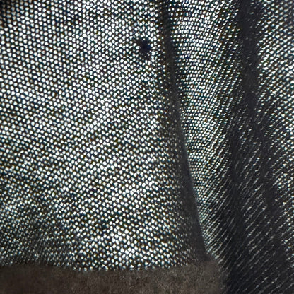 Close-up of a textured fabric surface with a hand holding it.