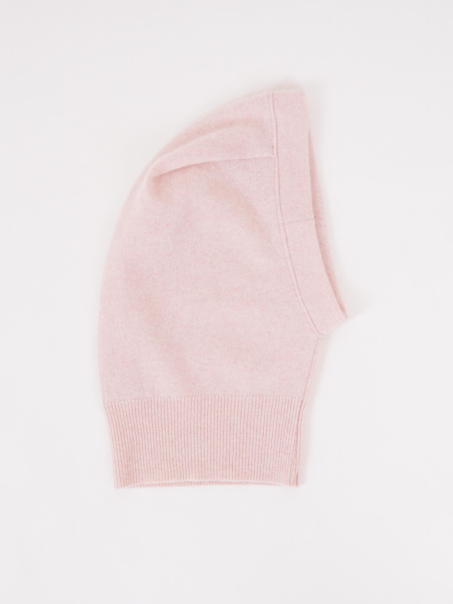 one folded light pink beanie  on a plain white background.