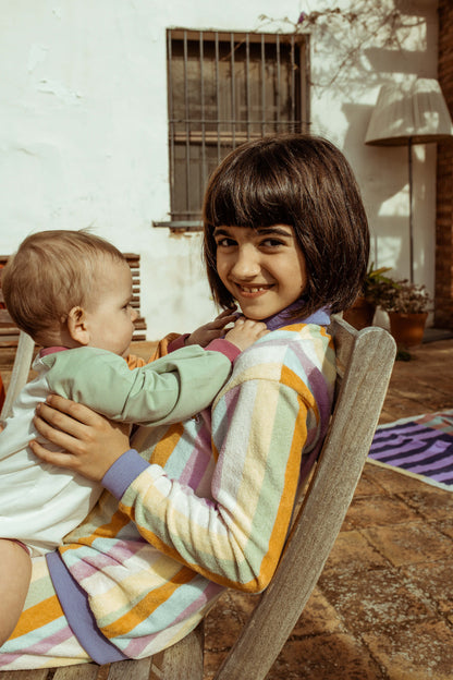 girl holding a baby outdoors in a casual setting