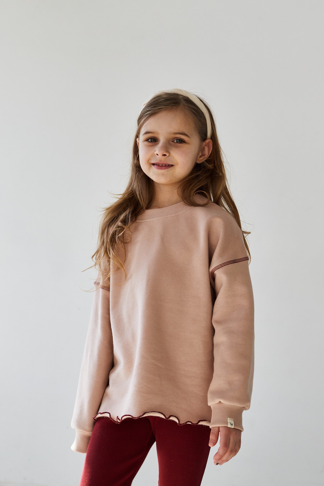 Girl wearing pink sweatshirt and red leggings