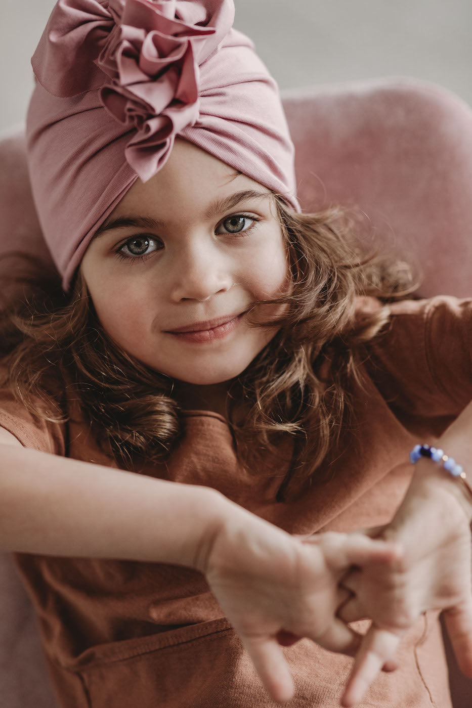 A smiling girl wearing a pink girl turban