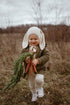 Child in a field wearing a bunny outfit holding carrots