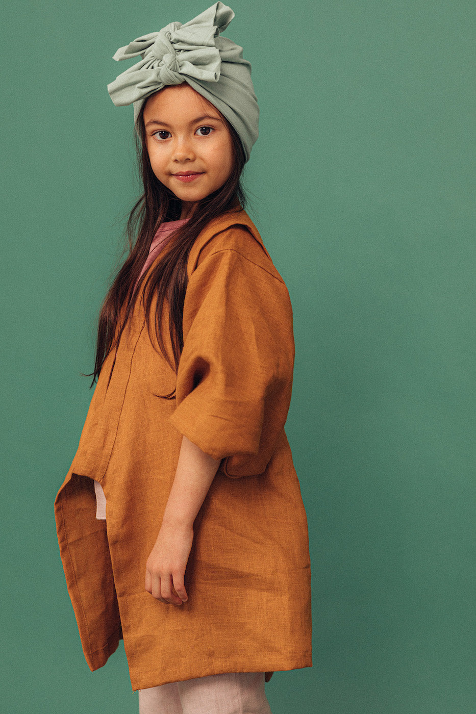 A girl with long brown hair wearing a vintage mint turban