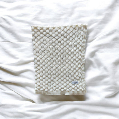 Textured blanket on a white fabric background