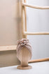 Organic Cotton Toddler Turban in color beige on a wooden mannequin with a wooden rack on the white beige wall in the background