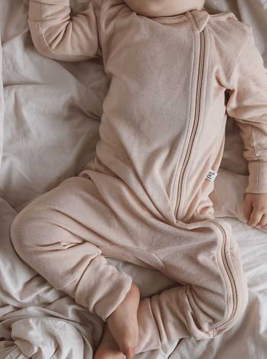 beige overall with a long zipper o na sleeping baby