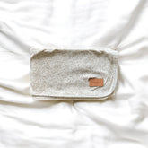Baby blanket with flower pattern with a leather tag on a white background
