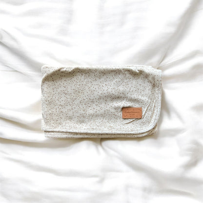 Baby blanket with flower pattern with a leather tag on a white background