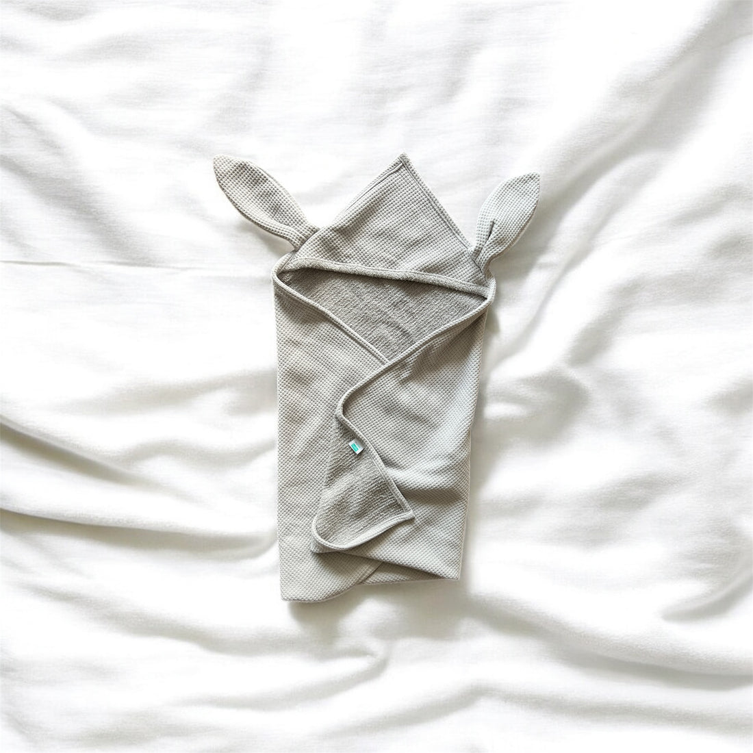 Gray textured towel with a knot on a white background