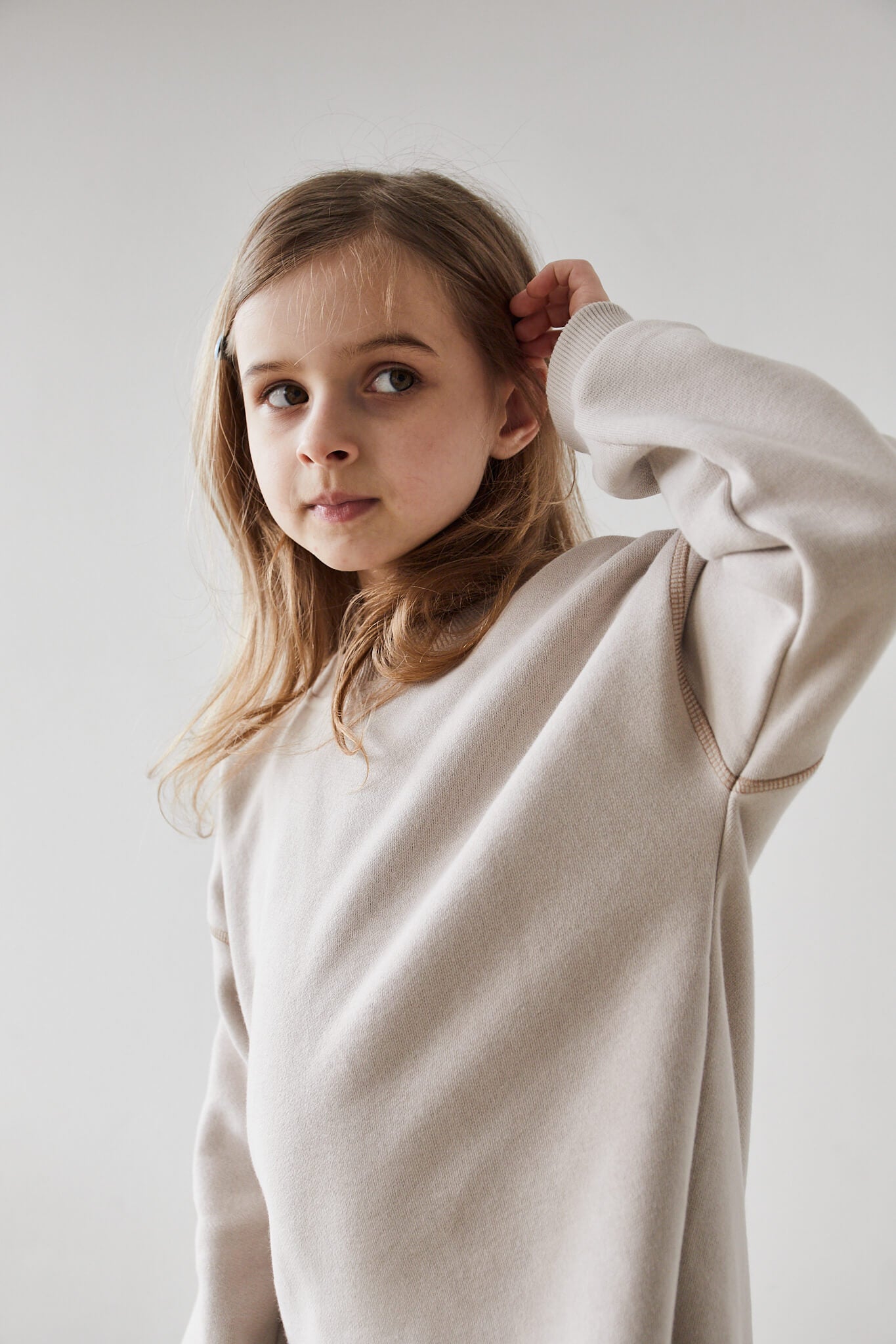 Girl wearing beige sweatshirt  on a white background